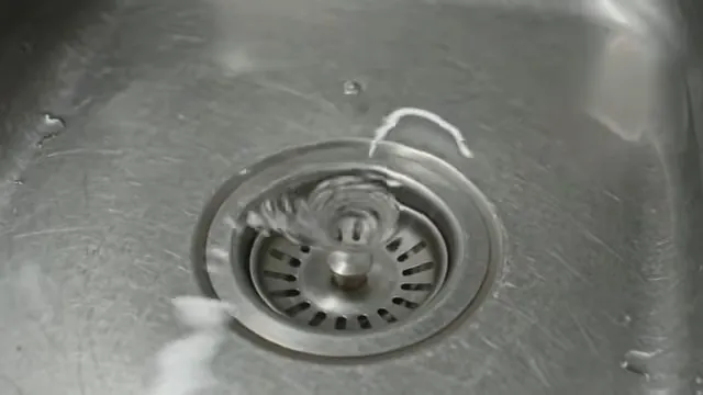 Water swirling around the strainer in a stainless steel kitchen sink drain