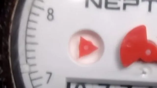 Close view of the red flow indicator on a water meter face